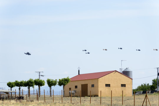 Three Boeing CH-47D Chinook helicopters flying in line with a Eurocopter Super Puma in front of the line