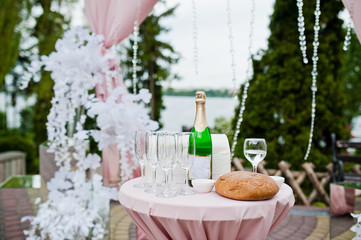 Close-up photo of glasses, bread and bottle of champagne on the table.