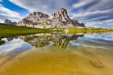 Amazing landscape shot from Italian mountains. Rock formation reflected in a lake. Long exposure. Travel, wander, discover, adventure.