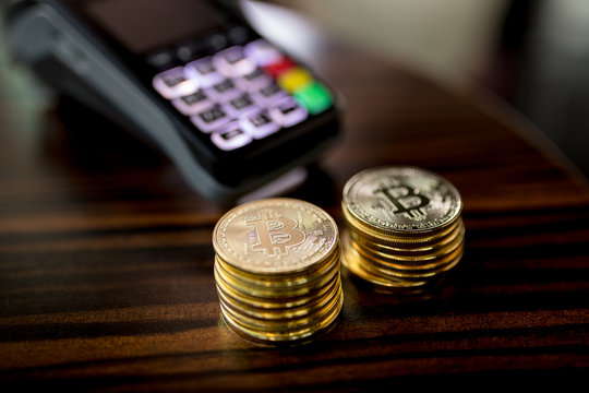 Golden Bitcoins with Credit card reader on the table. POS card.