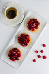 Tartlets with raspberries on a white plate