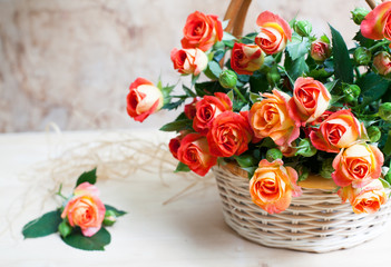 beautiful bouquet of roses in basket on wooden table, selective focus