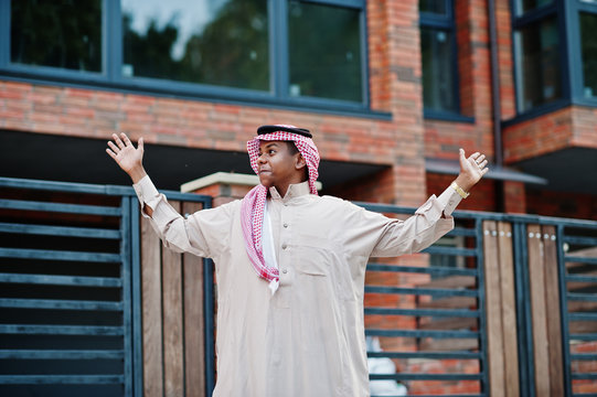 Middle Eastern arab man posed on street against modern building shows a surprise.