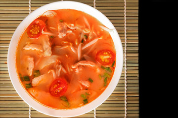 Tom Yum Gai or spicy tom yum soup with chicken - Authentic Thai style food. With ingredients: lemongrass, galangal, kaffir lime leaves, fresh chilies, and lime.
