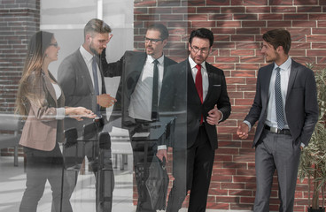 people standing in modern office behind glass wall