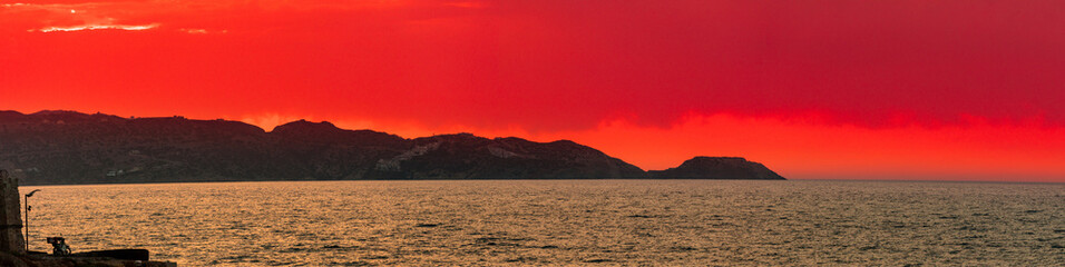 sunset at the sea with a view of the mountains in Heraklion Crete
