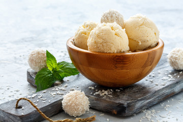 Fototapeta na wymiar Balls of coconut ice cream in a wooden bowl.