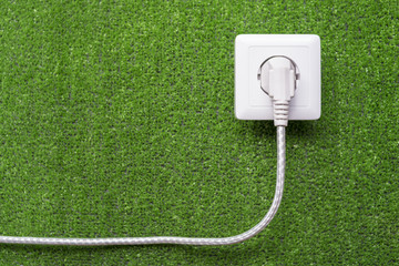 concept of ecological reception of an electricity. Electric socket and plug with a cord on a...