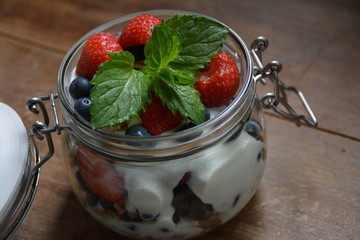 Joghurt mit Blaubeeren, Erdbeeren und Minzeblättern in einem Weckglas