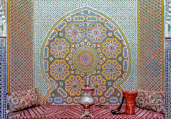 Mosaic walls and couches in a Moroccan riad in Fes