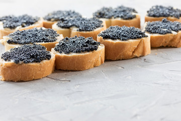 Expensive delicious black caviar white bread sandwich snack on a wooden plate