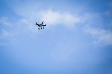 A drone hovering in a blue sky