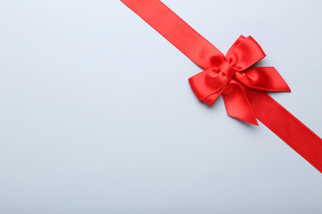 Red bow with ribbon on grey background