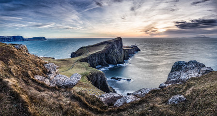 Fototapeta na wymiar End of land. Rocky coastline of Scotland. Cliffs with lighthouse. Sunset scenery. Landscape nature. Romantic. Ocean, wind, breeze, cold.