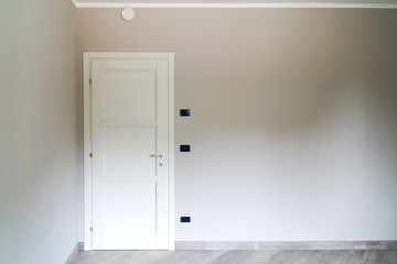 white door closed on gray wall