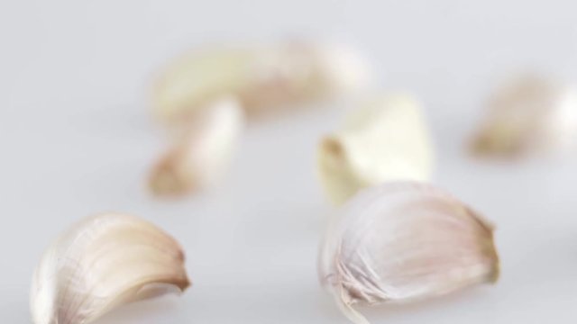 Macro shot of many pieces of garlic is on a white table with white background. Preparing for cooking.