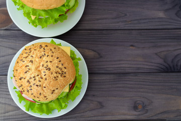 Sandwich with vegetables, top view on dark wooden background