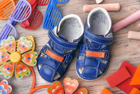Children's sandals on the background of children's toys