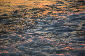 pebble stones on the sea beach, the rolling waves of the sea with foam