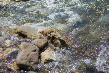 pebble stones on the sea beach, the rolling waves of the sea with foam