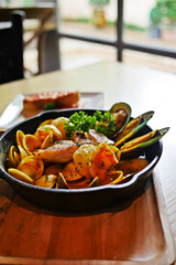 Sizzling hot Bouillabaisse,a traditional Provençal fish stew, with lots of seafood such as fish, shrimp, clams, mussels and enhance with saffron in a black cast iron pan served with Rouille. - obrazy, fototapety, plakaty