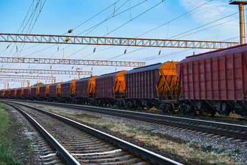 Fototapeta na wymiar railroad infrastructure during beautiful sunset and colorful sky, railcar for dry cargo, transportation and industrial concept