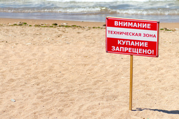 Sign "swimming is forbidden" on the beach. Russia. In Russian.