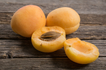 Naklejka na ściany i meble Group of apricots with kernel on wooden table. Closeup.