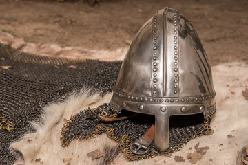 Replica of a medieval warrior medieval helmets and chainmail armor on genuine fur background