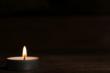 Obraz na płótnie Canvas Burning candle on black background