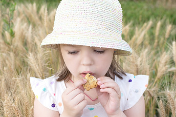 Little girl eat cookie on the open air