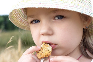 Little girl eat cookie on the open air