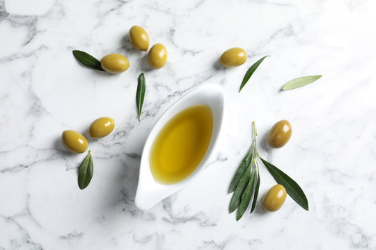 Flat lay composition with fresh olive oil on marble background