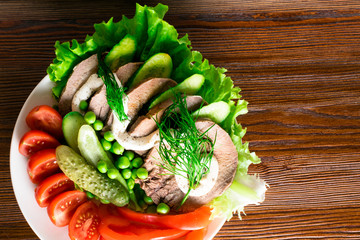 boiled tongue with vegetables tomatoes red pepper cucumber lettuce peas with mayonnaise with wooden...