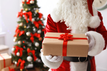 Authentic Santa Claus with gift box indoors