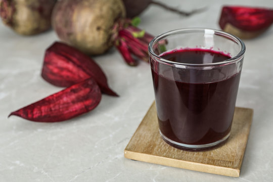 Glass with fresh healthy beet juice on table