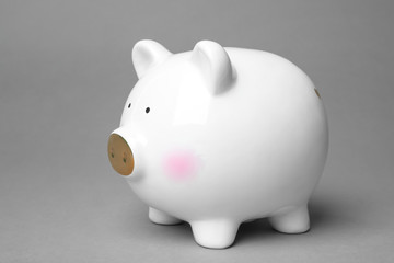 Cute white piggy bank on gray background