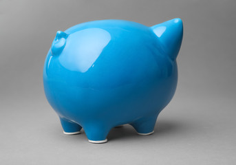 Cute blue piggy bank on gray background