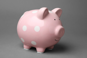 Cute pink piggy bank on gray background