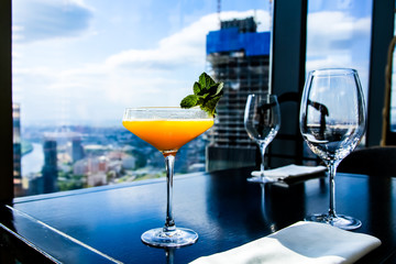 Yellow mango cocktail with mint leaf in a glass.