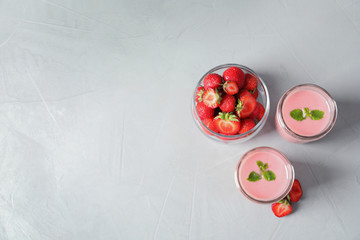 Glass jars with tasty strawberry smoothie on table, top view