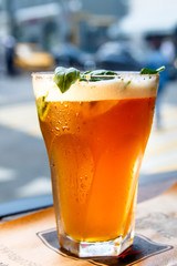 Iced tea in a misted glass is on the table.