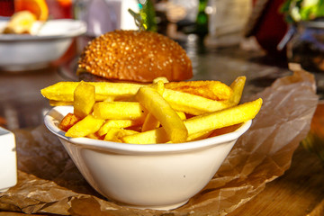 Burger with cheese, tomatoes, cucumbers, onions and fries is on the Board.