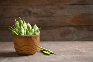 Bowl with fresh green beans on table