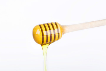 Honey dripping from a wooden honey dipper
