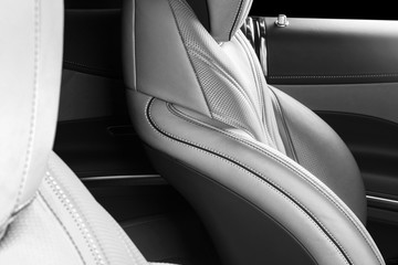 Modern Luxury car inside. Interior of prestige modern car. Comfortable leather red seats. Perforated leather. Modern car interior details. Black and white
