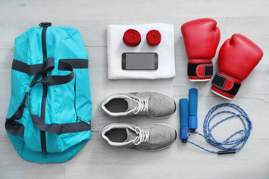 Flat lay composition with sports bag on wooden floor
