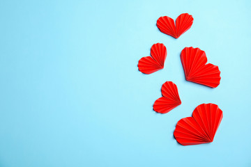 Small paper hearts on color background, top view