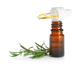 Small bottle with rosemary oil and fresh twig on white background