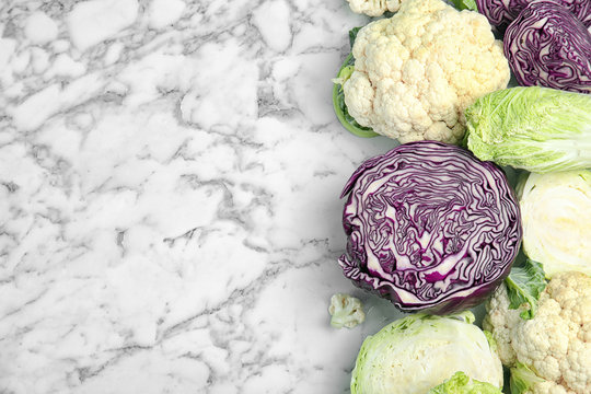 Flat lay composition with different cabbages on marble background
